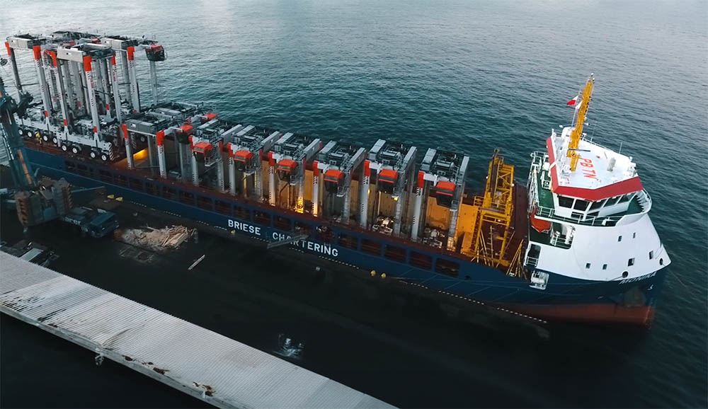 A drone view of the ship MV Monika in the harbor, loaded with 12 straddle carriers.